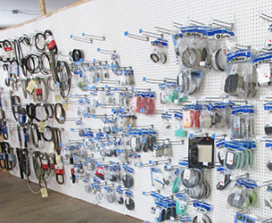 A wall with racks of power equipment parts and belts